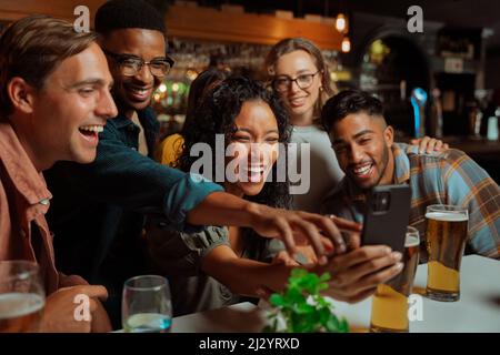 Groupe de jeunes amis adultes prenant des selfies au dîner assis au restaurant Banque D'Images