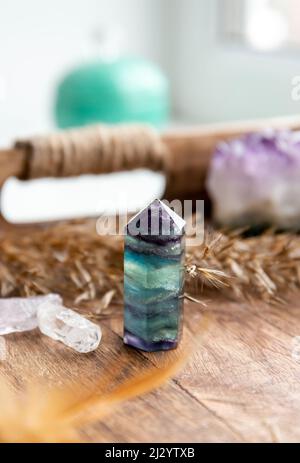 Cristal de fluorite translucide pierre précieuse dans la chambre de lit à la maison sur le plateau en bois naturel. Concept d'énergie de guérison et de compensation. Banque D'Images
