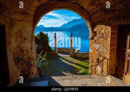 Vue sur la montagne depuis l'entrée de l'église Oratoire de S.Antonio da Padova à Santa Maria del Sasso avec la montagne et le lac de Lugano en une journée ensoleillée à Morcote, Tessin en Suisse. Banque D'Images