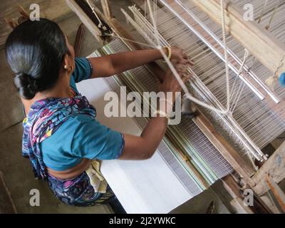 Inde, Gujarat, Kutch, Handloom Design Center à Bhujodi. Femme travaillant sur un textile de tissage de Pitloom. Ses pieds sont au-dessous du niveau du plancher. Banque D'Images