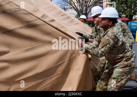 Base aérienne de Yokota, Tokyo, Japon. 23rd mars 2022. Sgt. Principal Jerry Dunn, chef de commandement de l'escadre du 374th Airlift, aide à retirer l'ancienne housse de protection contre la pluie de tente d'essai COVID-19 lors de son démantèlement à la base aérienne de Yokota, au Japon, le 23 mars 2022. Le retrait de la tente permettra d'augmenter l'espace de stationnement des patients à l'hôpital de base et de fournir des soins plus confortables et plus efficaces à l'intérieur de l'établissement. Credit: US Air Force/ZUMA Press Wire Service/ZUMAPRESS.com/Alamy Live News Banque D'Images