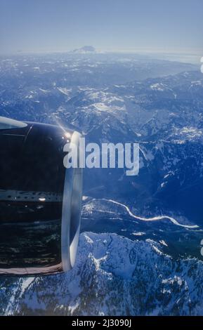 Vue par la fenêtre d'un Boeing 777 sur les montagnes Cascade avec le volcan Mount St. Helens. Banque D'Images