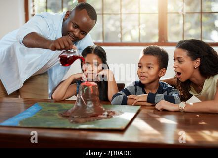 Il est temps de tester cette chose. Plan court d'un jeune couple aidant leurs enfants avec un projet d'école. Banque D'Images