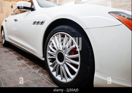 Roues de nouvelle voiture sport de luxe blanche dans un garage de détail. Banque D'Images