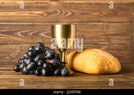 Tasse de vin avec raisins et pain sur fond de bois Banque D'Images