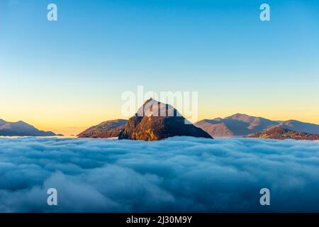 Mountain Peak San Salvatore au-dessus de Cloudscape avec lumière du soleil et ciel clair à Lugano, Tessin en Suisse. Banque D'Images