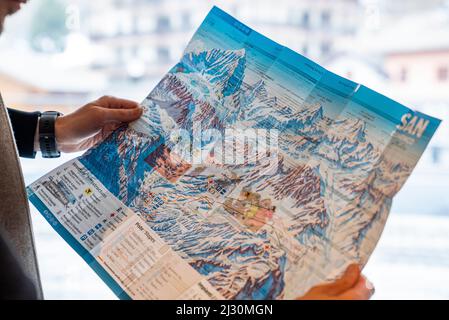 Des mains de touristes masculins explorant la carte de la station de ski et des pistes Banque D'Images