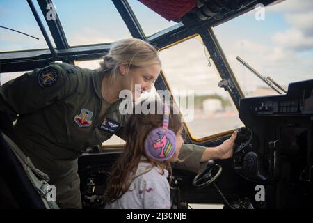Le 12 mars 2022 - Moody Air Force base, Georgia, USA - Capt Stephanie Stewart, commandant d'aéronef HC-130J combat King II, du 71st Escadron de sauvetage, enseigne à un enfant comment utiliser un étrier sur un HC-130J pendant la journée portes ouvertes de la jeunesse à la base aérienne Moody, Géorgie, 12 mars 2022. Le 6 septembre 2019, six aviateurs du groupe de sauvetage 347th ont effectué le premier vol de l'avion HC-130J combat King II devant être exploité par une équipage entièrement féminin. L'Open House de la jeunesse a culminé les femmes dans la semaine de l'aviation et avait pour but de connecter une jeune génération aux aviateurs et des inspirer pour des carrières dans l'air pow Banque D'Images