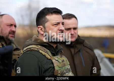 Le président ukrainien Volodymyr Zelenskiy visite la ville de Bucha, alors que l'attaque de la Russie contre l'Ukraine se poursuit, Bucha, au nord-ouest de la capitale ukrainienne Kiev, le lundi 4 avril 2022. Le président ukrainien Volodymyr Zelensky a déclaré le 3 avril 2022 que les dirigeants russes étaient responsables des meurtres civils à Bucha, à l'extérieur de Kiev, où des corps ont été retrouvés dans la rue après que la ville ait été reprise par l'armée ukrainienne. Le ministère russe de la Défense a rejeté les accusations le même jour, arguant que les forces russes ont quitté Bucha le 30 mars, alors que des preuves de meurtres ont été présentées quatre jours plus tard. Photo Banque D'Images