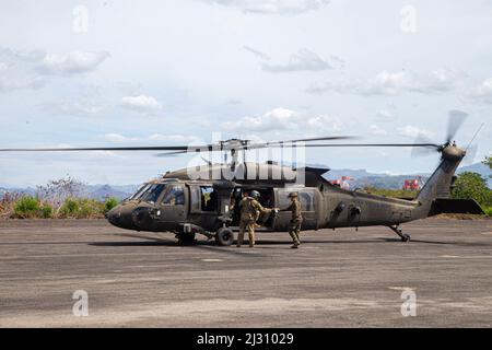 Un Marine américaine affecté à l'escadron de soutien de l'escadre Marine 172 (MWSS-172) et un soldat de l'Armée de terre de la Brigade de l'Aviation de combat 25th, 25th Division d'infanterie, se préparent à terminer le ravitaillement d'un hélicoptère HAWK UH-60 à un point d'armement et de ravitaillement par l'avant pendant le Balikatan 22 à Subic Bay (Philippines), le 3 avril 2022. Balikatan est un exercice annuel entre les forces armées des Philippines et l'armée américaine visant à renforcer l'interopérabilité bilatérale, les capacités, la confiance et la coopération bâtie sur des décennies d'expériences partagées. Balikatan, Tagalog pour ‘de chaulder-à-épaule,’ est une ancienne Banque D'Images