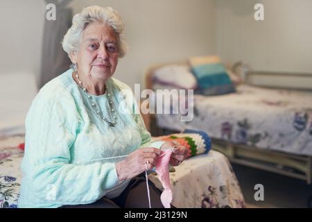 Je le rends pour mon petit-enfant. Portrait d'une femme âgée triant dans une maison de vieillesse. Banque D'Images