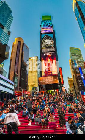NEW YORK, Etats-Unis OCT 4, 2017: Les gens sont assis dans les escaliers rouges avec la publicité au néon des nouvelles, des marques et des théâtres à Times Square en fin d'après-midi. Fois squat Banque D'Images