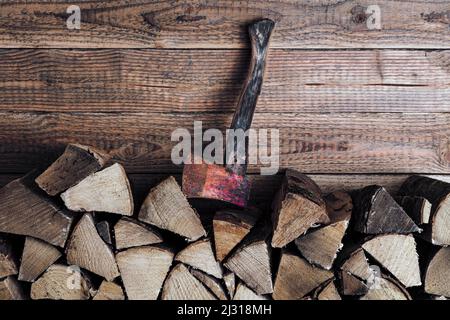 Brennholzstapel mit AXT vor Holzwand Banque D'Images