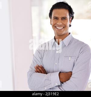 HES un pro. Un beau jeune homme d'affaires chez lui. Banque D'Images