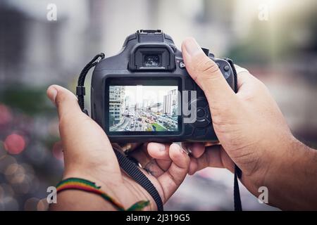 Capturer le chaos de la ville. Prise de vue d'un homme méconnaissable prenant des photos avec un appareil photo dans la ville. Banque D'Images