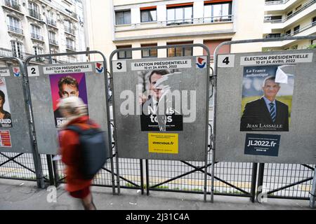 Un piéton passe devant des affiches déchirées de la campagne, sur un panneau d'affichage électoral (panneau). Affiches présidentielles sur leurs conseils électoraux. Illustration le 4 avril 2022 à Paris, France. Les électeurs français se rendront aux urnes le 10 avril 2022 pour le premier tour de l'élection présidentielle. Photo de Victor Joly/ABACAPRESS.COM Banque D'Images