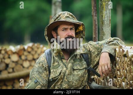 Portrait de l'aventure sérieux homme Extreme explorer. Chasseur d'homme en camouflage extérieur. Chasseur brutal, homme barbu dans la forêt sauvage à l'automne Banque D'Images
