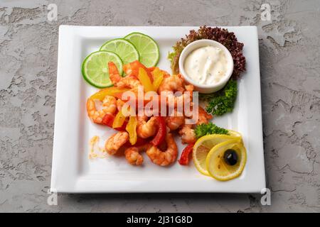 Crevettes frites avec légumes sur plaque blanche avec sauce Banque D'Images