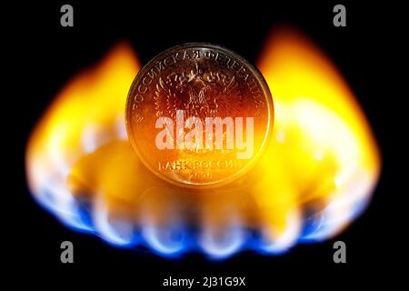 L'arrière de pièce rouble avec les armoiries de la Russie sur le brûleur à gaz de la cuisinière de cuisine. Le concept de la Russie qui vend du gaz naturel pour des roubles. Banque D'Images