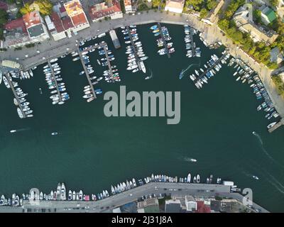 Vue panoramique aérienne du paysage de Balaklava avec des bateaux et la mer dans la baie de la marina au coucher du soleil. Attraction touristique de Crimée Sébastopol. Vue de dessus de drone Banque D'Images