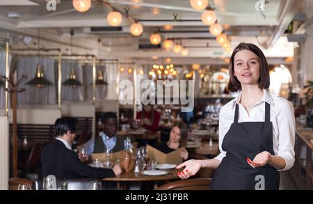 Une serveuse rencontre les clients au restaurant Banque D'Images