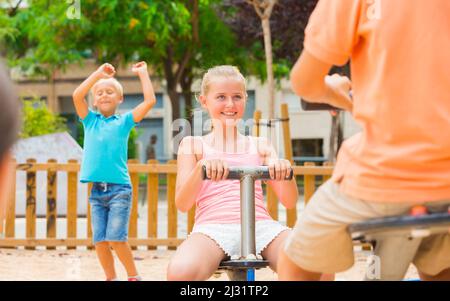 Les enfants sont en train de teetering sur la balançoire Banque D'Images