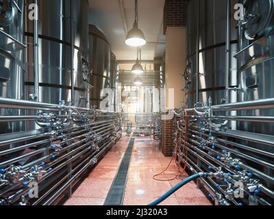 Réservoirs à bière avec beaucoup de tuyaux en acier dans la brasserie artisanale. Banque D'Images