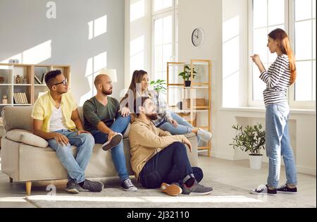 Groupe multiracial de jeunes jouant des charades lors d'un rassemblement amical à la maison Banque D'Images