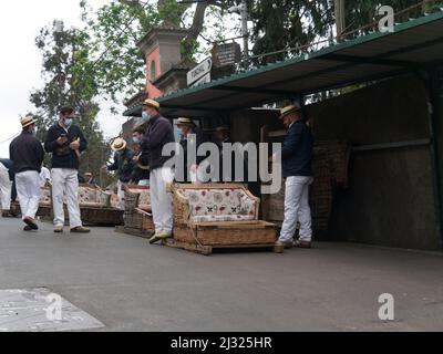 Des hommes attendent les touristes pour faire un toboggan en osier sur la route de Livramento Monte Funachal Madeira Portugal eu Banque D'Images