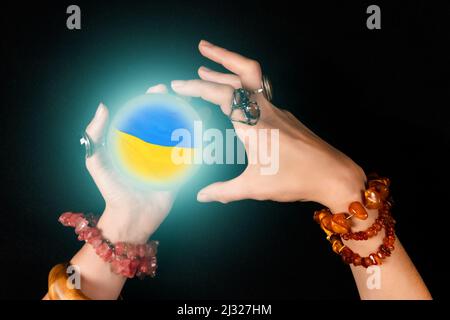 Concept de l'avenir de l'Ukraine. magic ball peint dans les couleurs du drapeau ukrainien et des mains d'une sorcière ou d'un apaisant. Banque D'Images