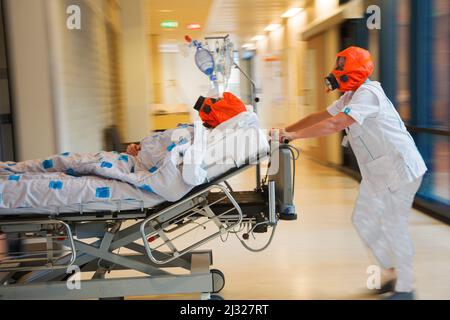 Pays-Bas, Nimègue, exercice d'incendie à l'hôpital. L'infirmière et le patient portent un masque d'évacuation , un masque à gaz pour les protéger de la fumée ou d'un autre gaz pendant la durée de l'opération Banque D'Images