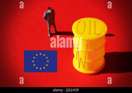 Homme d'affaires miniature devant un baril de pétrole avec un graphique du marché, et drapeau européen, concept du prix du pétrole. Banque D'Images