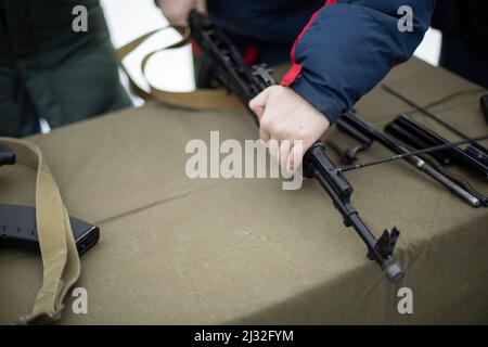 Assemblage du fusil d'assaut AK 47. Armes à feu fusil d'assaut Kalashnikov. Les gens ramassant le pistolet factice. Entraînement militaire. Banque D'Images
