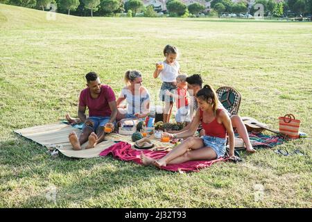 Familles heureuses s'amuser à faire un pique-nique dans le parc en plein air pendant les vacances d'été - Focus sur le visage d'enfant de garçon Banque D'Images