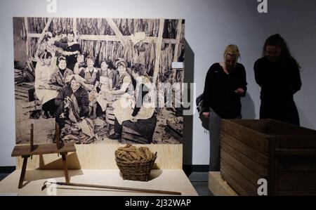 05 avril 2022, Saxe, Chemnitz: Une photo historique du photographe Gerhard Weber de 1984 montre les employées d'une usine de tabac dans le district de Leipzig et leur équipement de travail. La photo fait partie de l'exposition « Tabakrausch an der Elbe » (ruée vers le tabac sur l'Elbe), qui peut être vue au Musée industriel de Chemnitz du 8 avril au 30 décembre 2022. En coopération avec le Musée de la ville de Dresde, on rappelle l'histoire de la Saxe comme lieu de l'industrie du tabac; avant la première Guerre mondiale, chaque seconde cigarette en Allemagne venait de Dresde. Photo: Sebastian Willnow/dpa Banque D'Images