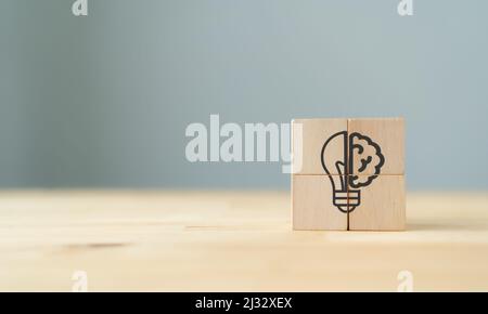 Concept d'idée créative. Les cubes en bois avec icône ; une moitié de lumière bulbe et cerveau isolé sur fond gris avec espace de copie. Symbole de créativité, n Banque D'Images