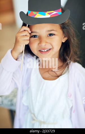 Vous aimez mon chapeau de fantaisie. Portrait d'une petite fille mignonne posant avec des accessoires d'habillage à la maison. Banque D'Images