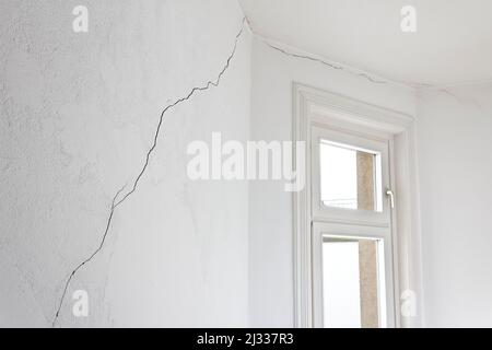 Concept de dommages à la construction: Fissure très longue dans le mur d'un appartement ou d'un appartement dans une maison ancienne, causée par un tremblement de terre ou un glissement de terrain. Banque D'Images