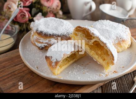 Des poches de pâte feuilletée remplies de crème aigre délicieuse servi comme dessert sur une table basse Banque D'Images