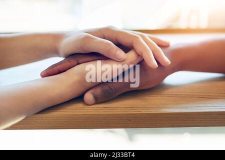 Je suis toujours là pour vous. Prise de vue d'une jeune femme non identifiable tenant les mains d'un ami en consolation. Banque D'Images