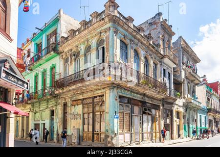 Vieux bâtiment résidentiel aux intempéries dans un coin d'une rue de la ville. Les Cubains dans leur vie quotidienne sont vus dans la région. Avec l'économie en ruine, Banque D'Images