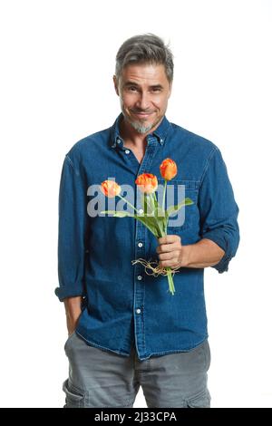Homme blanc plus ancien décontracté tenant bouquet de fleurs, tulipes, isolé sur blanc, souriant. Banque D'Images