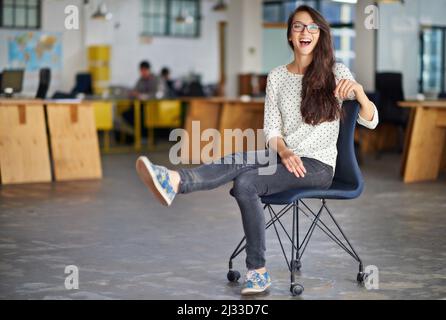 C'est un lieu de travail bien frais. Portrait d'une jeune femme attrayante assise dans un bureau. Banque D'Images