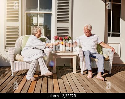 Heres à plus de matins comme ça. Photo d'un heureux couple senior en dégustant du jus sur le patio à la maison. Banque D'Images