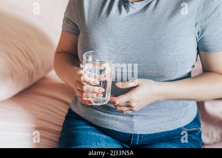 Journée mondiale de l'eau. Elle tient un verre d'eau propre dans ses mains. Concept de soins de santé. Boire de l'eau le matin pour stimuler le métabolisme. Banque D'Images