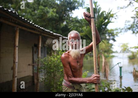 Un homme âgé est vu dans une zone inondée de Sunamganj, dans le nord-est du Bangladesh, le 16 juillet 2020. Chaque année, des millions de personnes touchées par les inondations dues à de fortes pluies et à des cours d'eau débordant dans les parties nord-est et nord-ouest du Bangladesh. De nombreuses personnes sont mortes, déplacées, ont perdu leurs récoltes, leurs maisons, souffrent de nourriture et d'eau potable pure pendant l'inondation de la mousson. Banque D'Images