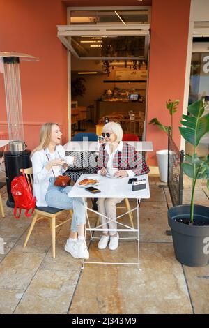 Deux femmes heureuses prenant un café au café Banque D'Images