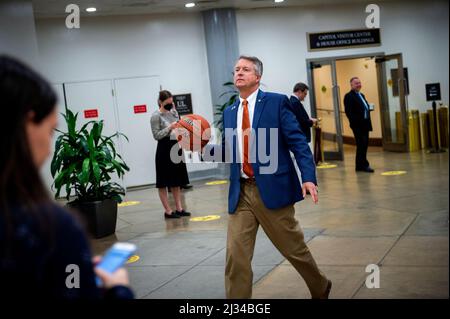 Washington, États-Unis d'Amérique. 05th avril 2022. Le sénateur américain Roger Marshall (républicain du Kansas) porte un ballon de basket-ball NCAA qu'il avait signé par des sénateurs de Caroline du Nord, alors qu'il marche dans le métro du Sénat au Capitole des États-Unis lors d'un vote à Washington, DC, le mardi 5 avril 2022. Sur le basket-ball est écrit le score final du match de basket-ball masculin NCAA de la nuit dernière entre les Jayhawks du Kansas et les talons de goudron de Caroline du Nord crédit: Rod Lamkey/CNP/Sipa USA crédit: SIPA USA/Alay Live News Banque D'Images