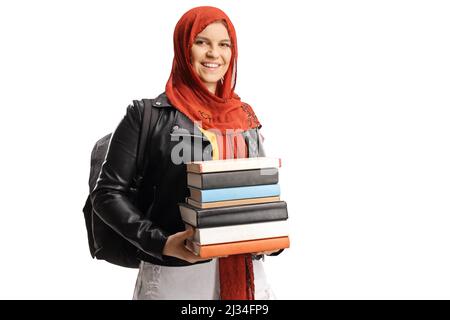 Une étudiante avec un hijab portant une pile de livres et souriant à la caméra isolée sur fond blanc Banque D'Images