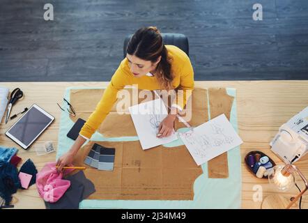 Le bureau d'un designer. Photo en grand angle d'une jeune créatrice de mode dans son atelier. Banque D'Images